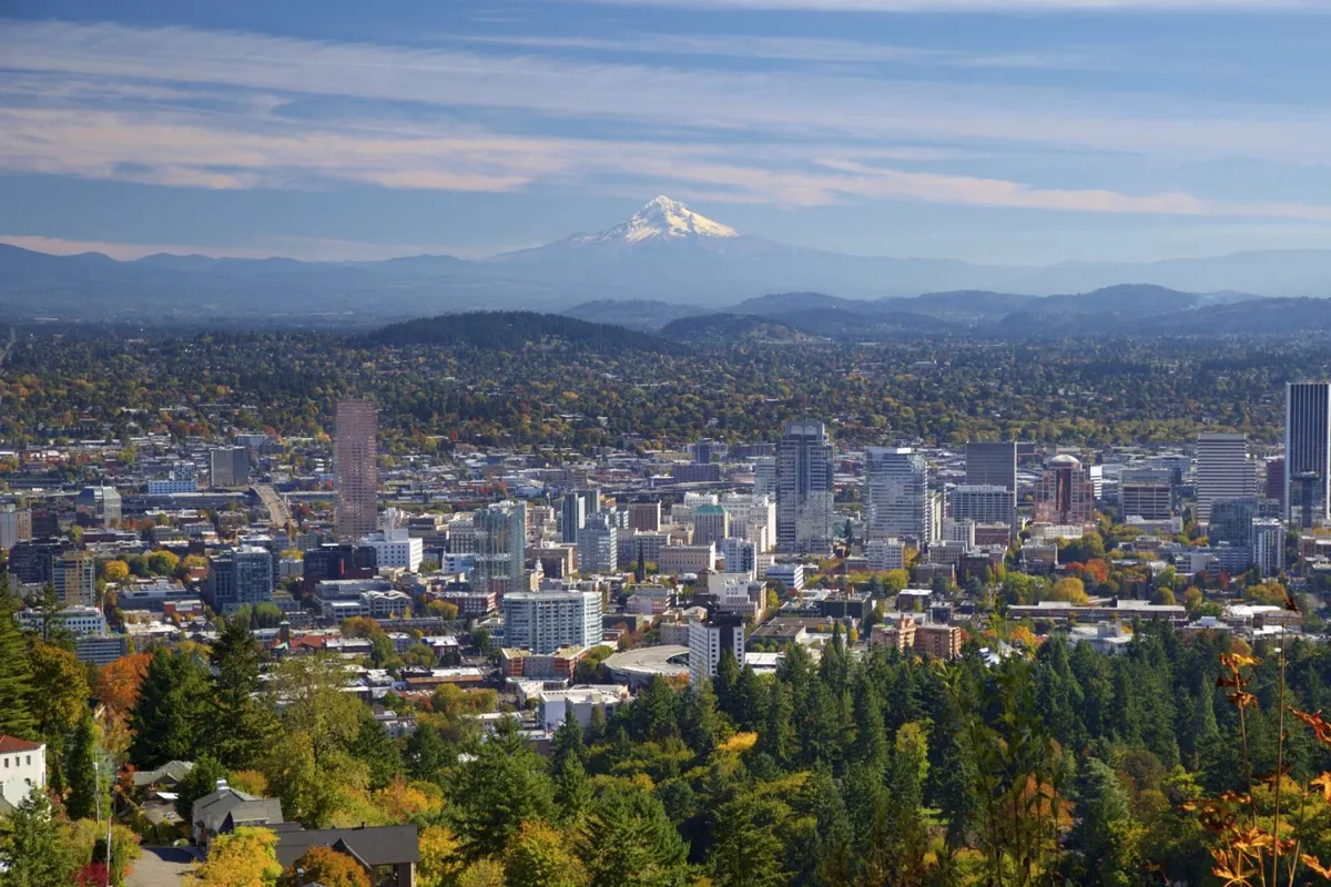 A sweeping view of Mount Hood, downtown Portland, and colorful fall foliage, capturing the natural beauty and urban vibrancy of the region. The expansive landscape invites exploration and adventure just a short drive from the home.