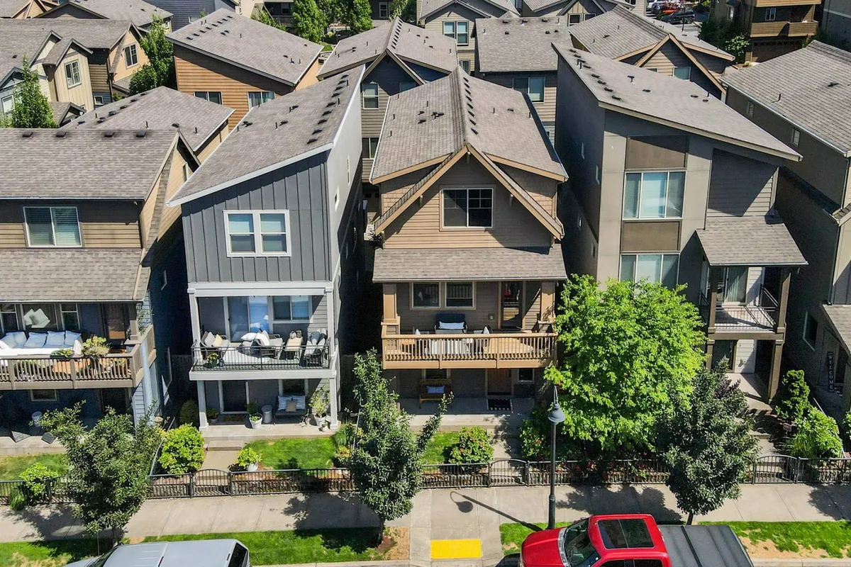 The image highlights a friendly neighborhood scene, featuring various residential houses, mature trees, and front porches. The setting evokes a sense of community and is ideal for social gatherings, morning walks, or family outings.