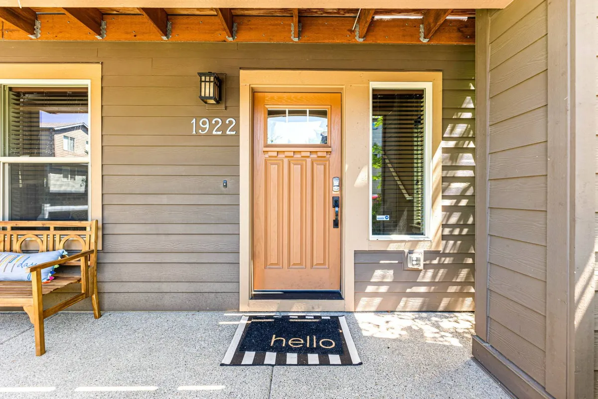 This image captures the welcoming front entrance of The Swoosh House, featuring a prominent front door, a friendly welcome mat, and a bench for relaxing or waiting. The scene conveys a sense of arrival and hospitality, setting the stage for convenience and comfort.